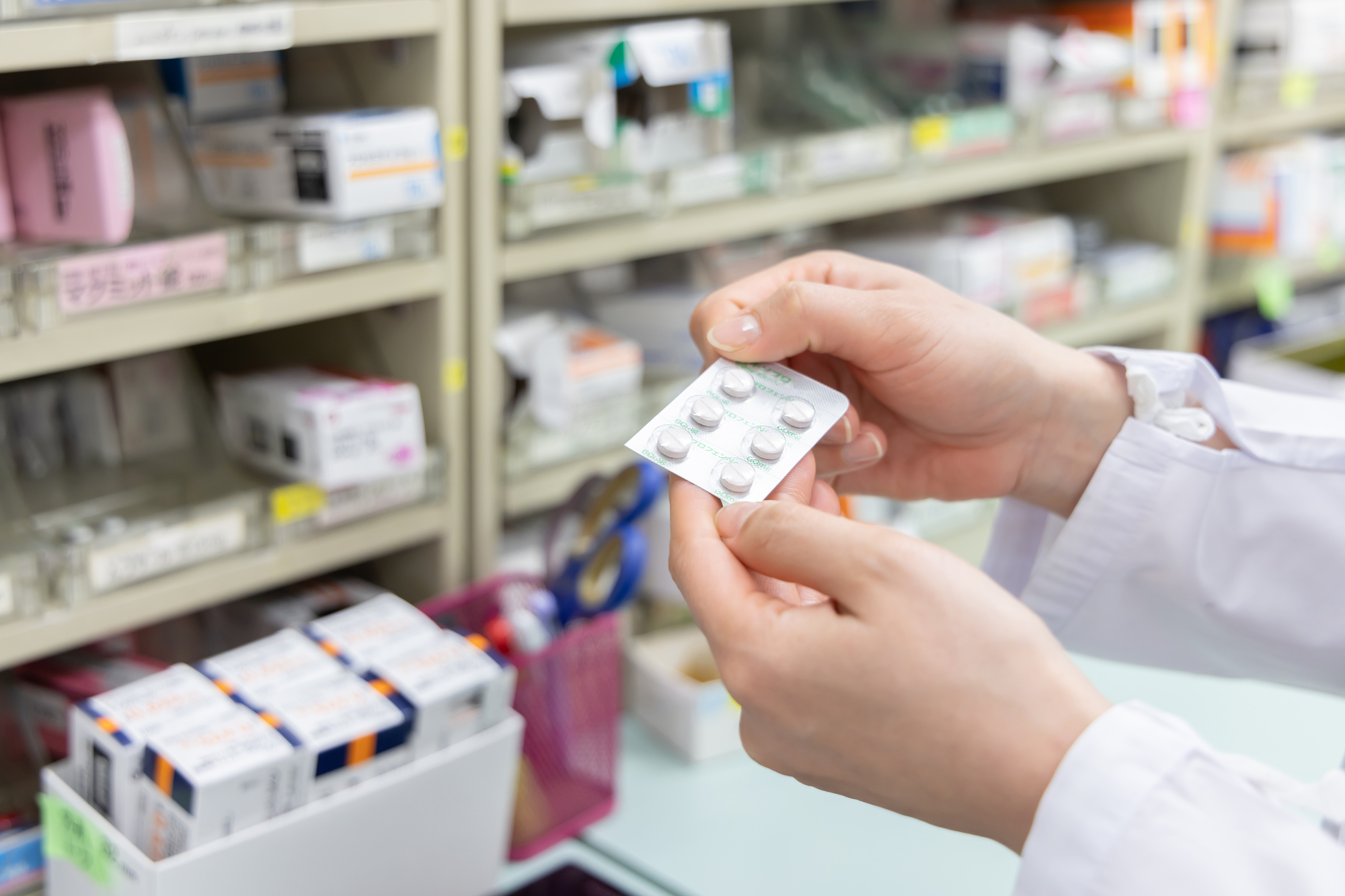 薬を確認する男性薬剤師